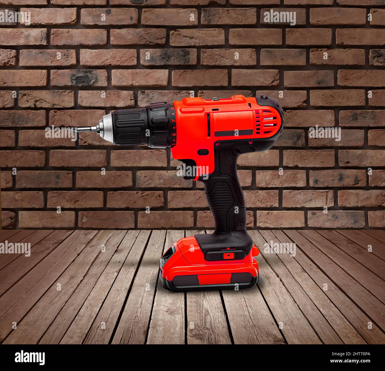 Red electric cordless screwdriver drill on wooden background, professional  home repair tool Stock Photo - Alamy