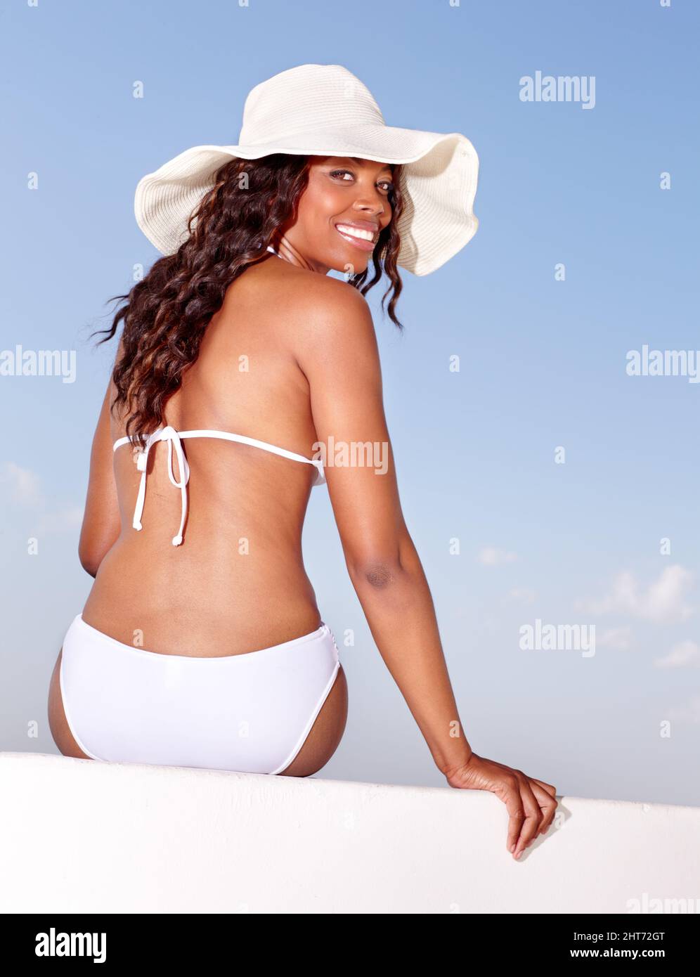 Summer beauty under the African sun. Rear view of a beautiful African woman in a bikini basking in the summer sun. Stock Photo