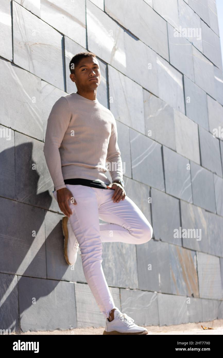 Portrait of a Hispanic male posing in trousers and a white pullover Stock Photo