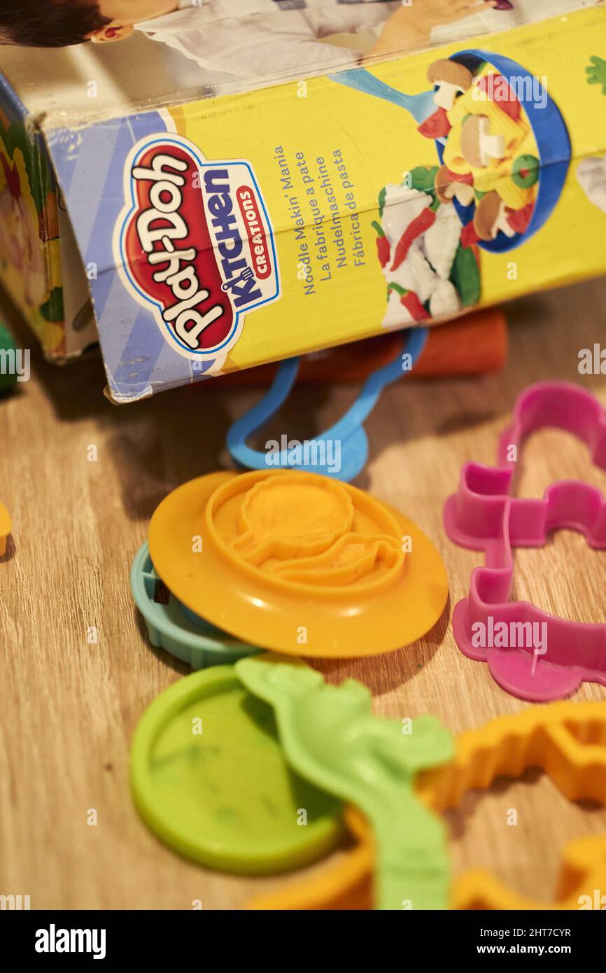 Vertical shot of a box of Play-Doh with plastic cut-out shapes next to it Stock Photo