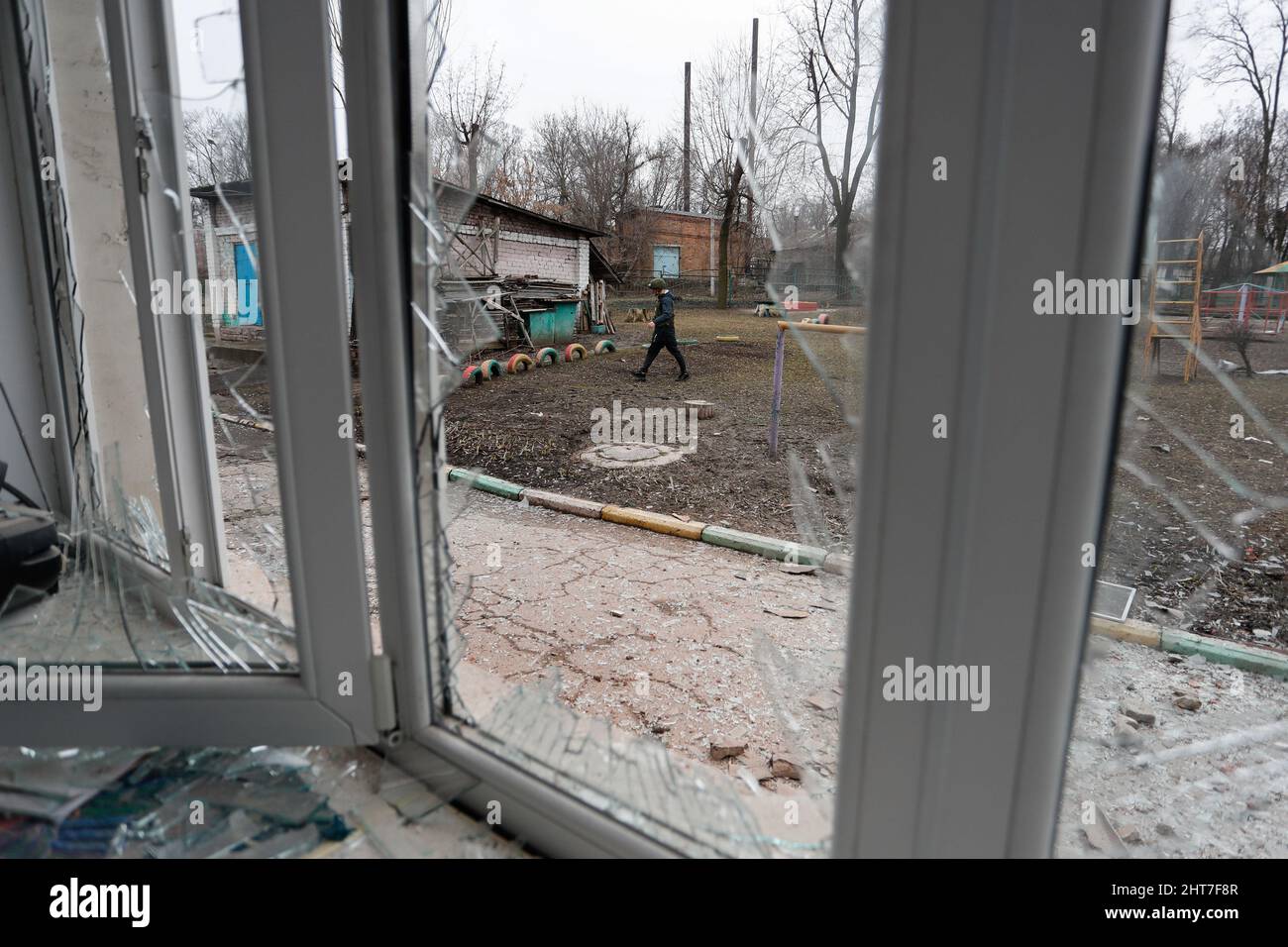 (220227) -- MOSCOW/KIEV, Feb. 27, 2022 (Xinhua) -- A journalist passes a damaged building in Donetsk, Feb. 26, 2022. (Photo by Victor/Xinhua) Stock Photo