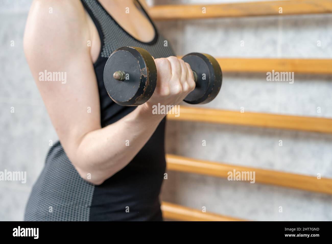 Spanish woman doing dumbbells exercise in a Physical therapy clinic