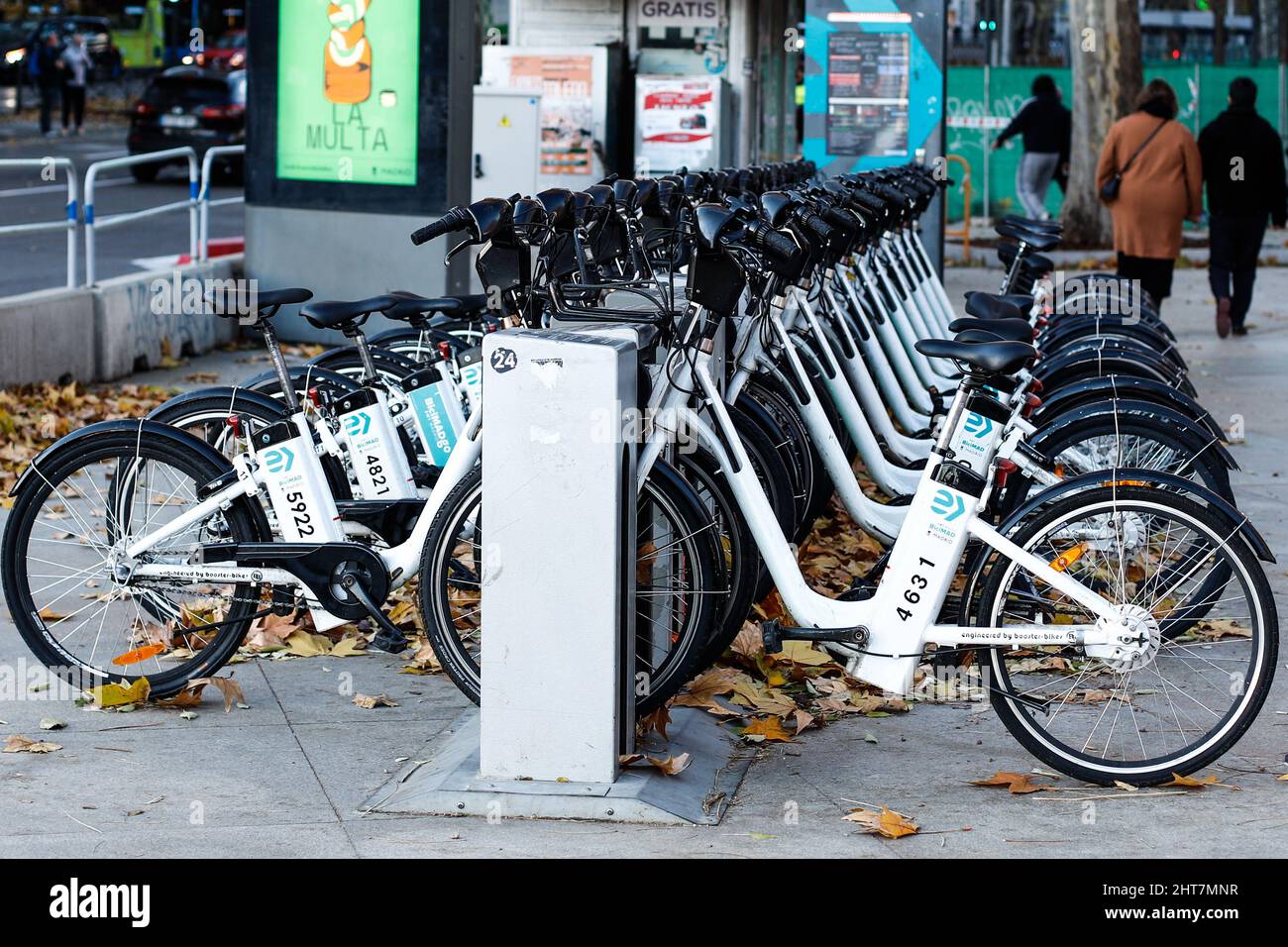Row of electric bikes charging at a station in Madrid, Spain Stock