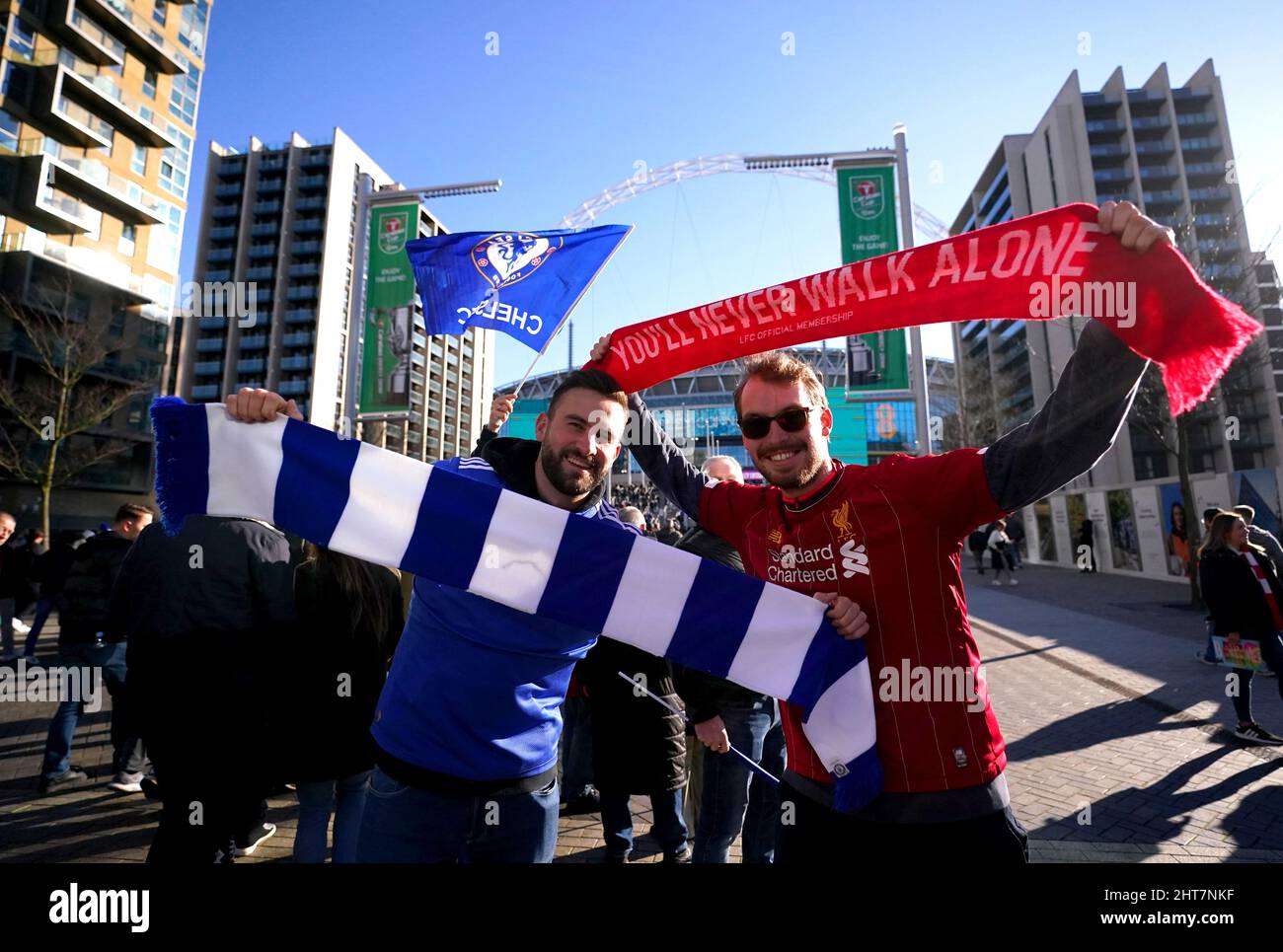 A Chelsea fan and a Liverpool fan pose for a photo outside of the