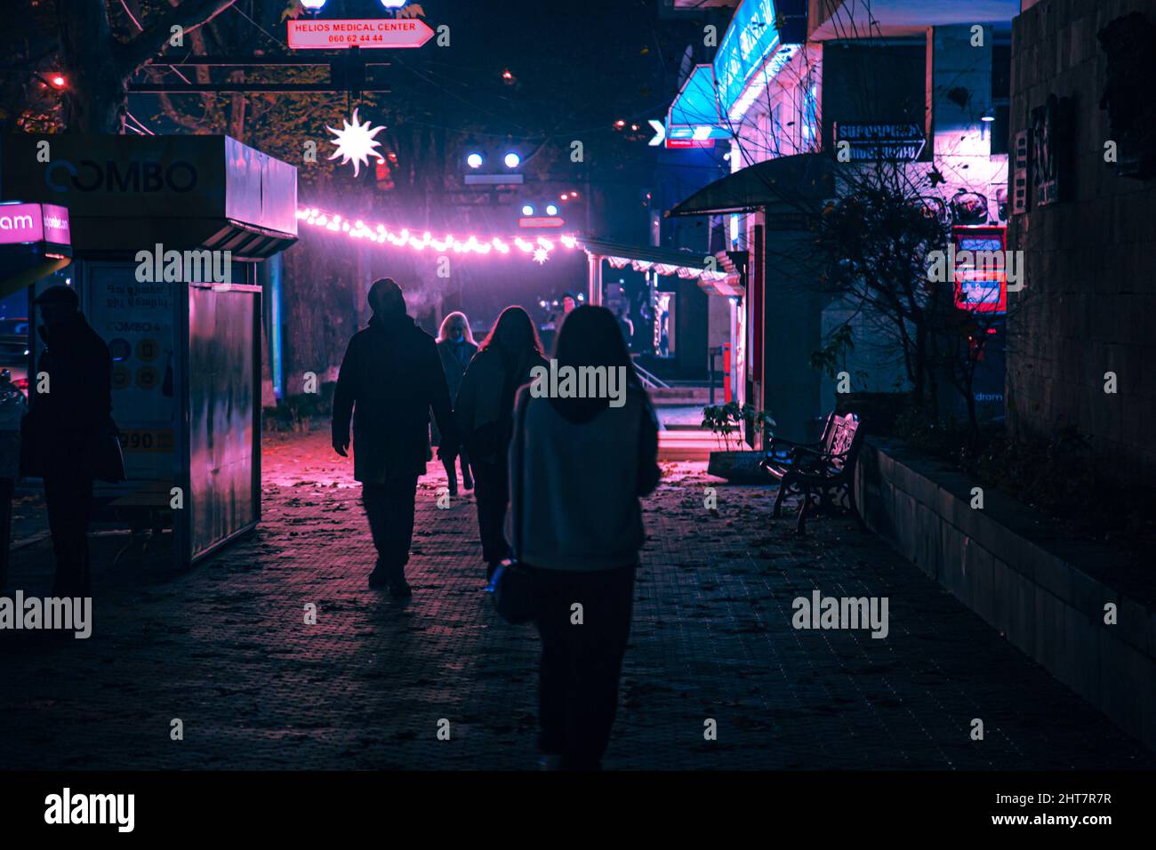 Rear view of people walking on the street at night Stock Photo - Alamy
