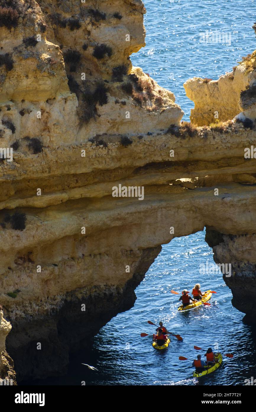 kayaking around rocky arch on beach Praia do Camilo in Lagos, Algarve, Portugal Stock Photo