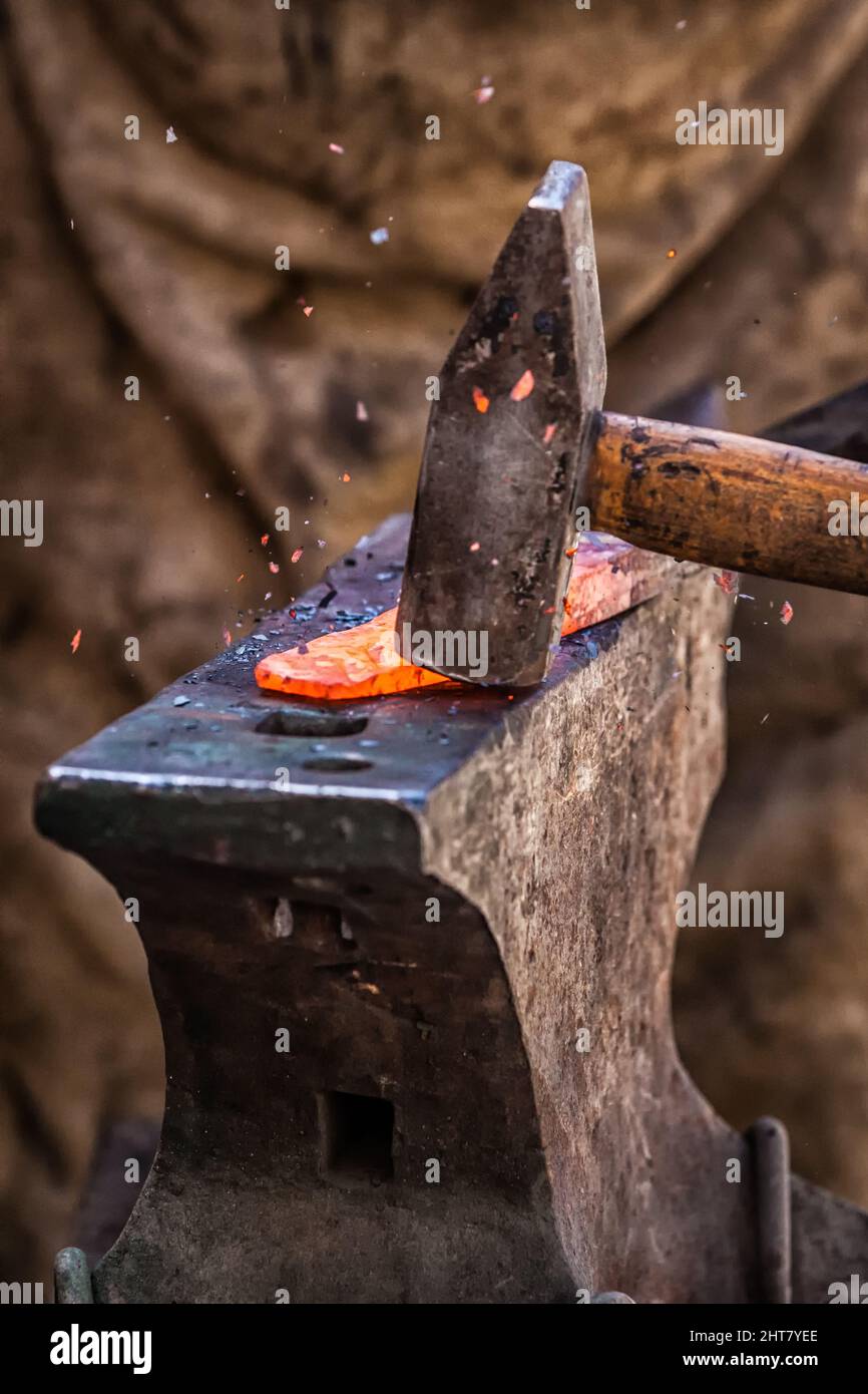 A Sword smith shaping a blade on an anvil Stock Photo