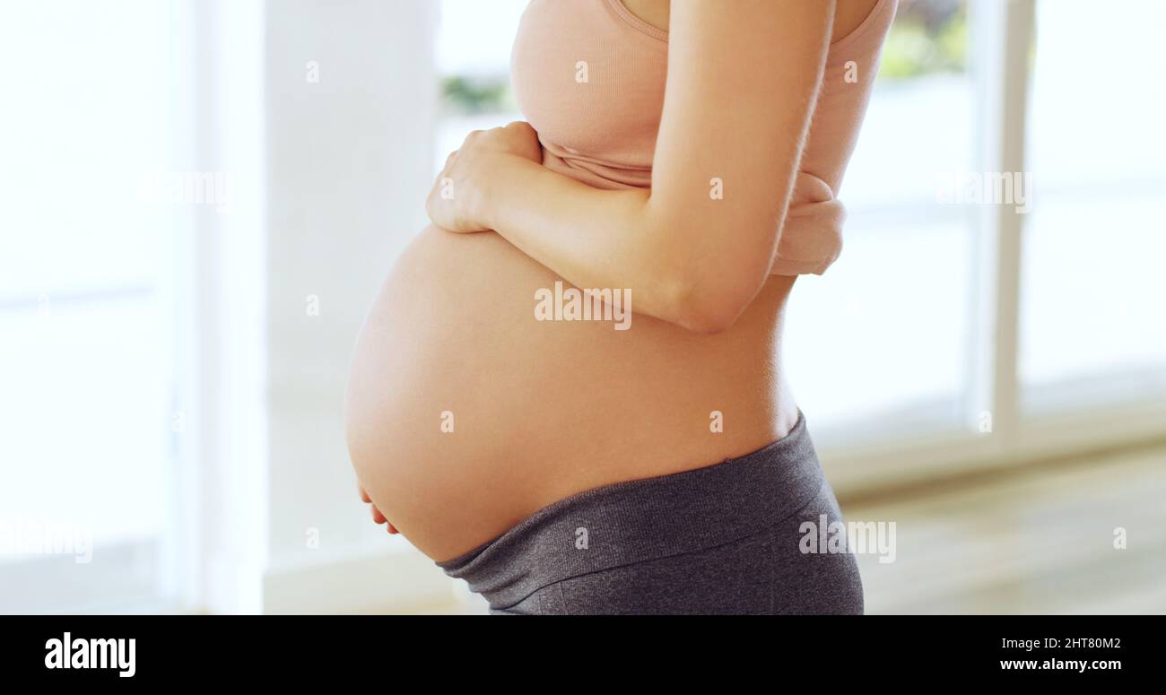 Im in love with a child I havent met yet. Shot of a pregnant woman holding her belly at home. Stock Photo