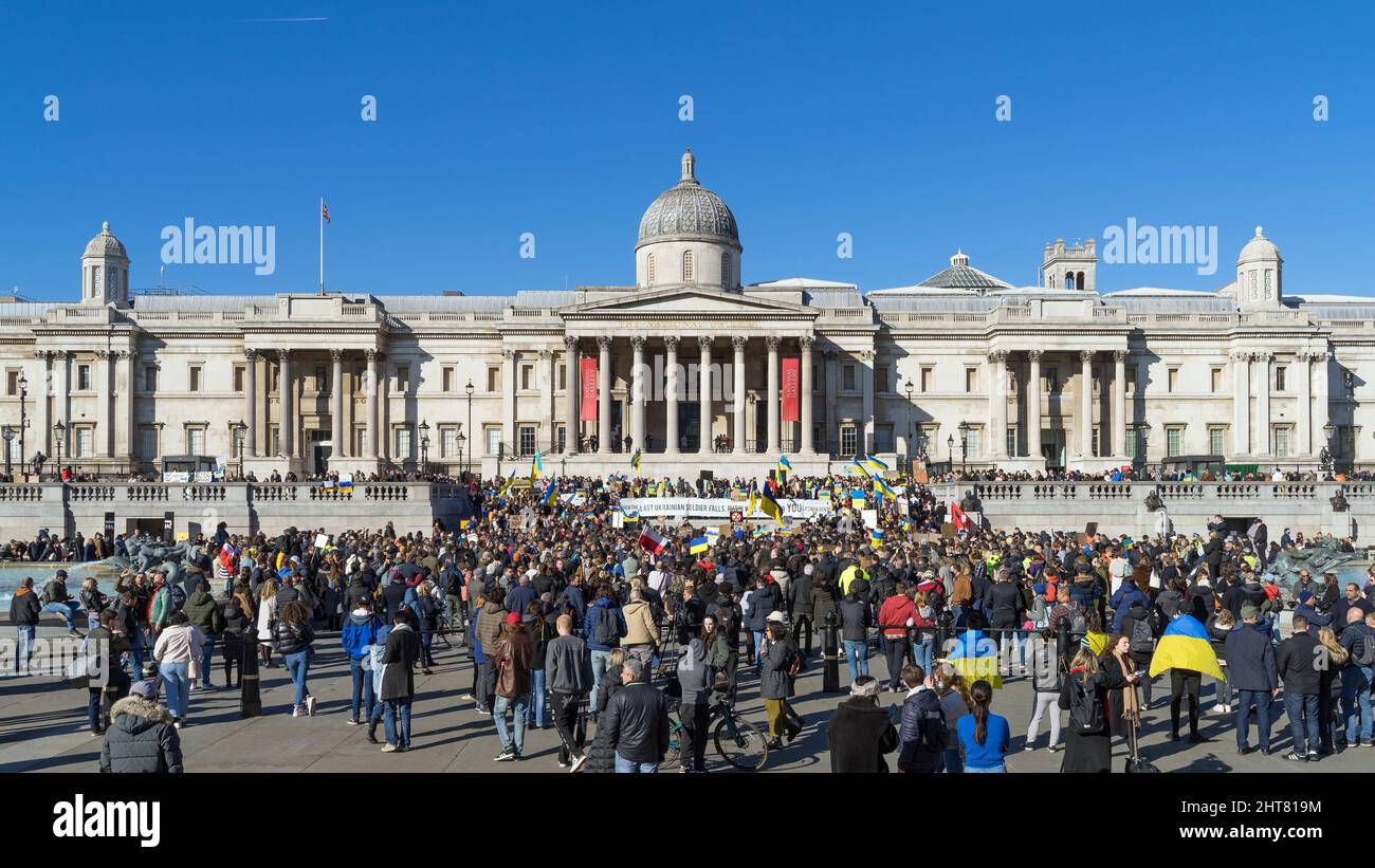 Protest against the Russian invasion of Ukraine in Trafalgar Square. A large group of protestors holding banners and Ukrainian flags. London Stock Photo