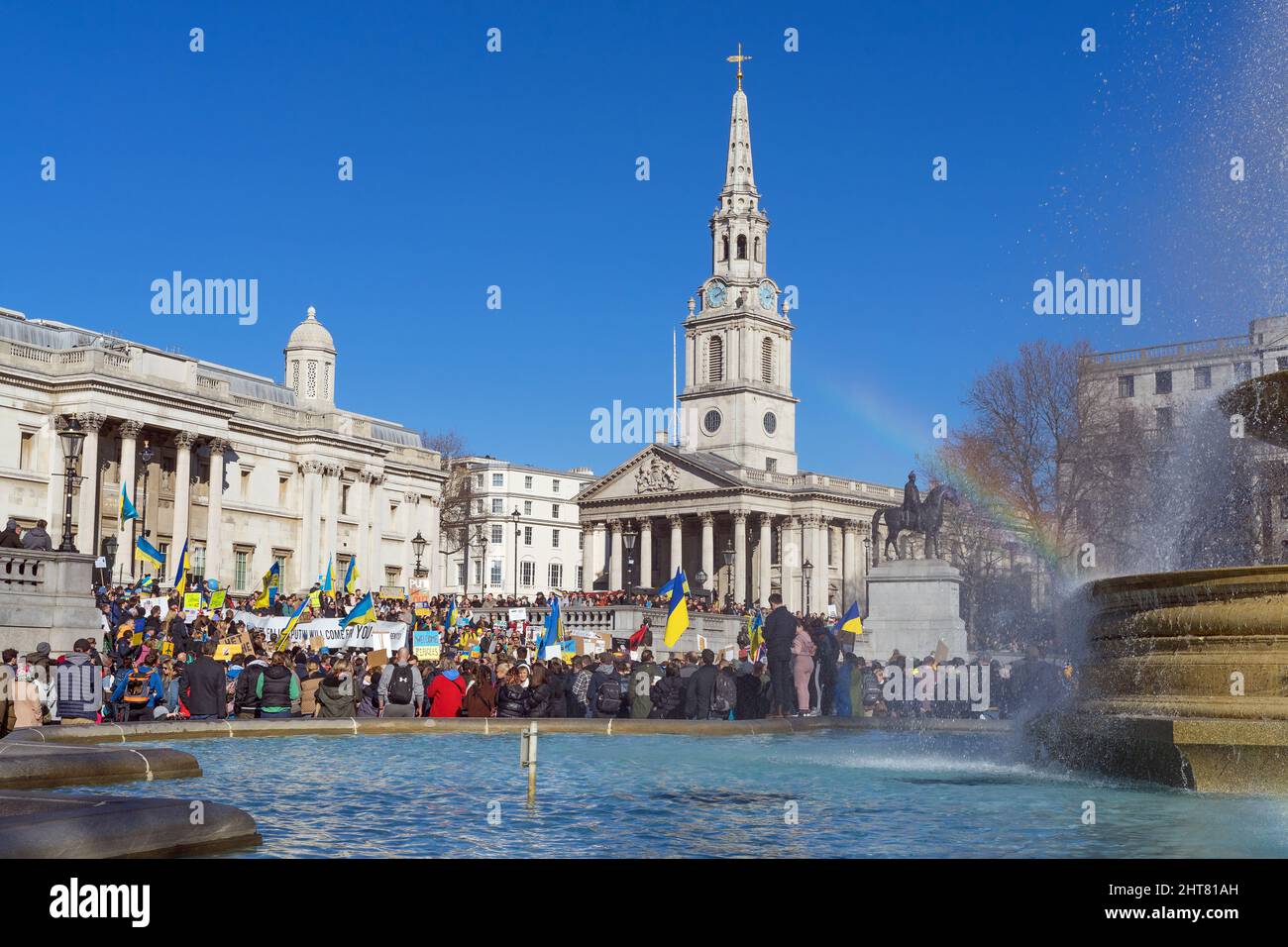 Protest against the Russian invasion of Ukraine in Trafalgar Square. A large group of protestors holding banners and Ukrainian flags. London Stock Photo