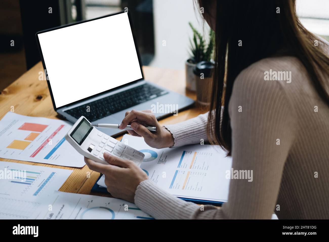 Close up Business woman using calculator for audit finance budget on wooden desk in office, tax, accounting, statistics and analytic research concept. Stock Photo