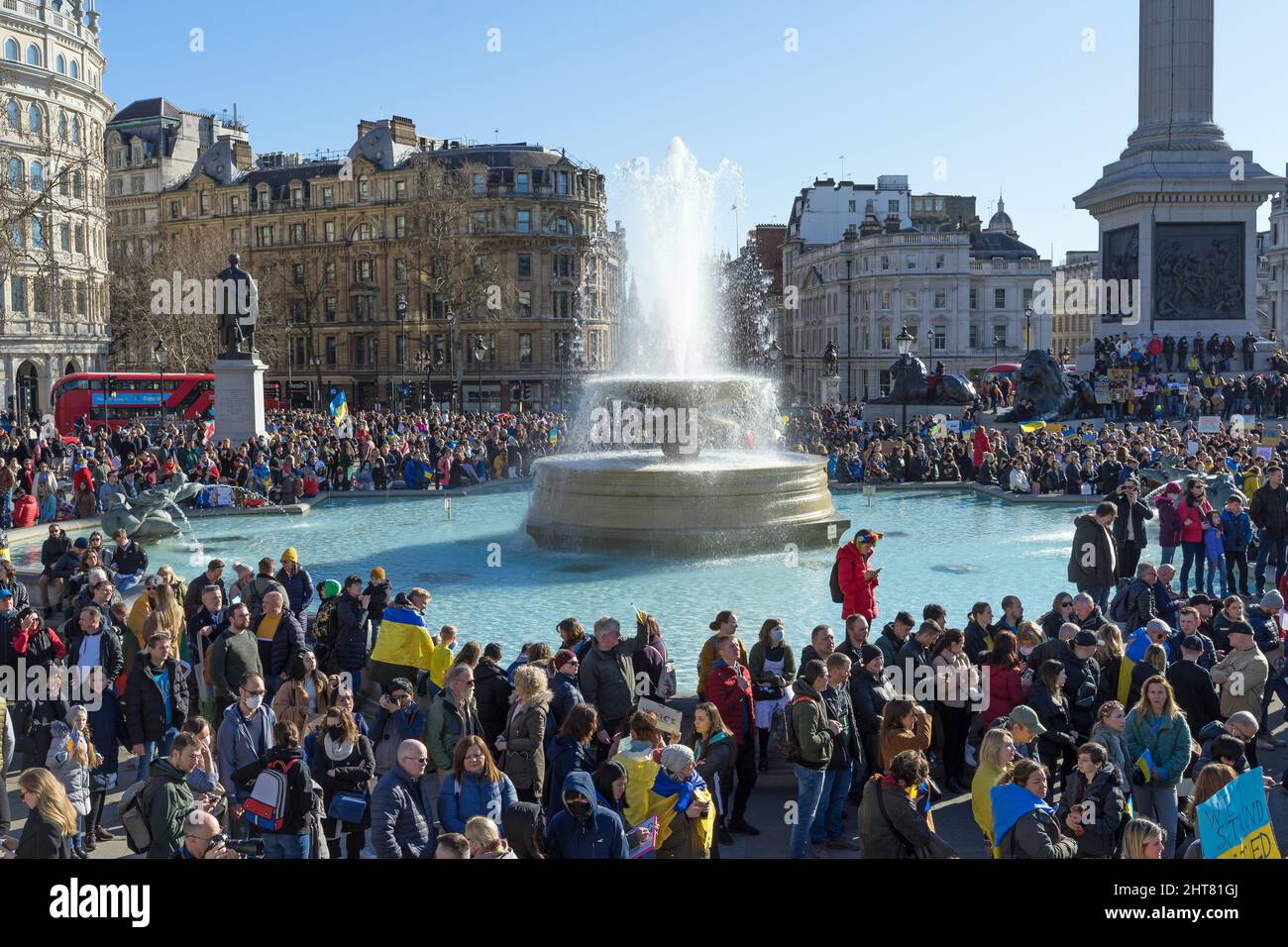 Protest against the Russian invasion of Ukraine in Trafalgar Square. A large group of protestors holding banners and Ukrainian flags. London Stock Photo