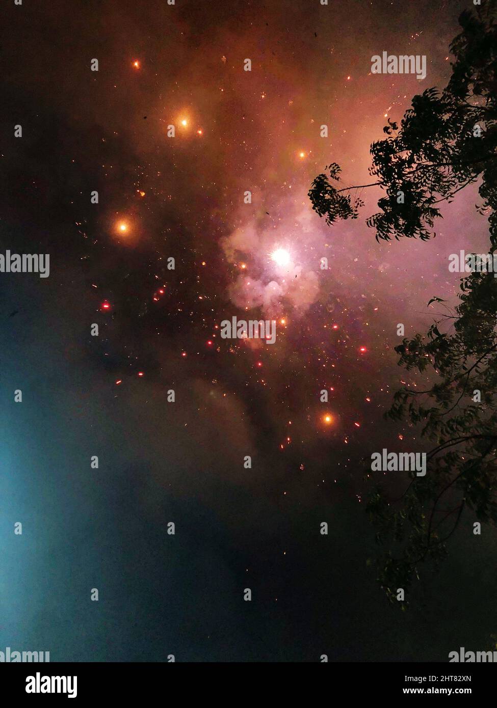 Vertical shot from the ground of firecrackers in the sky. Stock Photo
