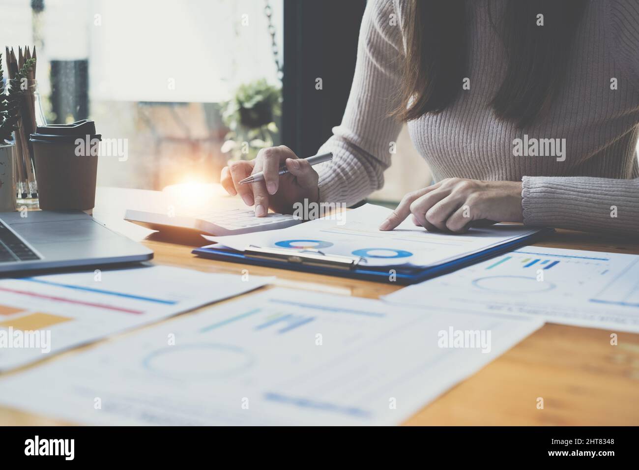 Close up Business woman using calculator for audit finance budget on wooden desk in office, tax, accounting, statistics and analytic research concept. Stock Photo