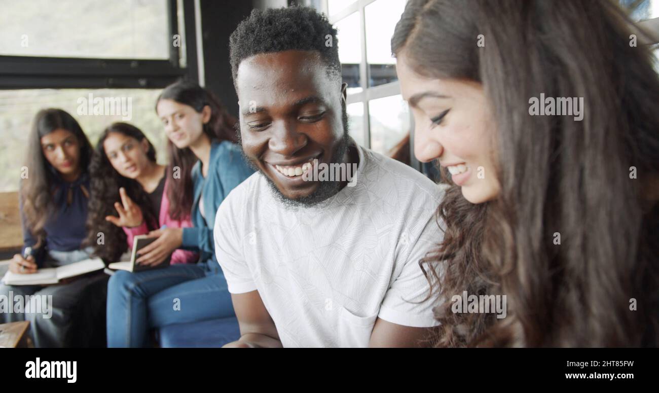 Group of young happy smiling students gathered and studying together ...