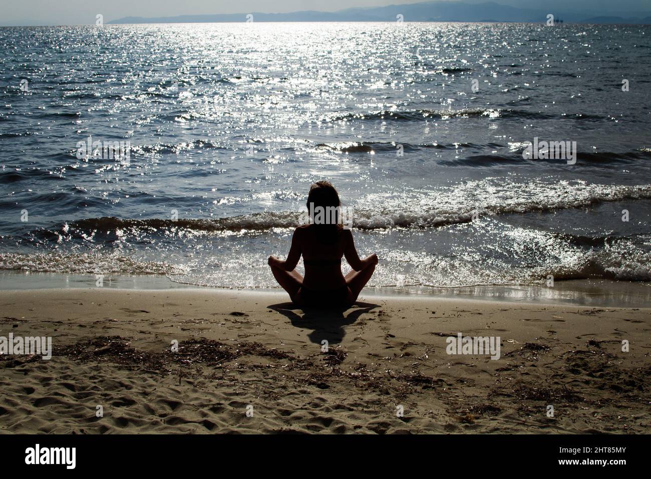 Silhouette of a woman meditating on the beach Stock Photo - Alamy