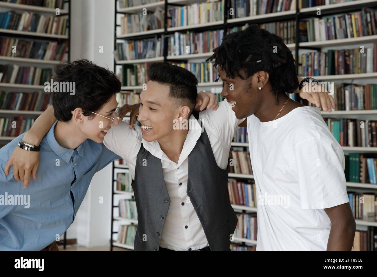 Joyful millennial multiracial college friends having fun in campus. Stock Photo