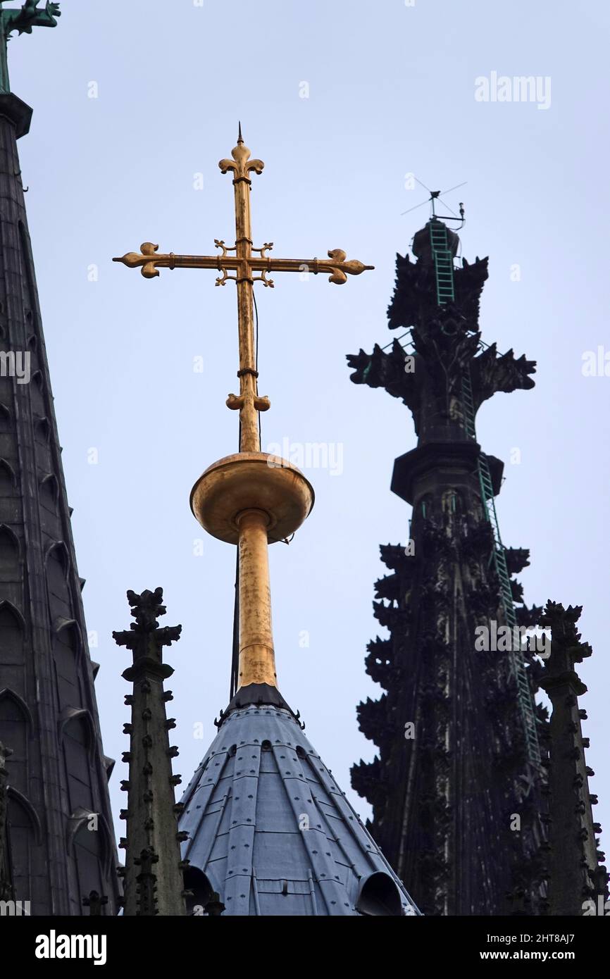 Golden cross on the roof of the Cologne Cathedral against the sky Stock Photo