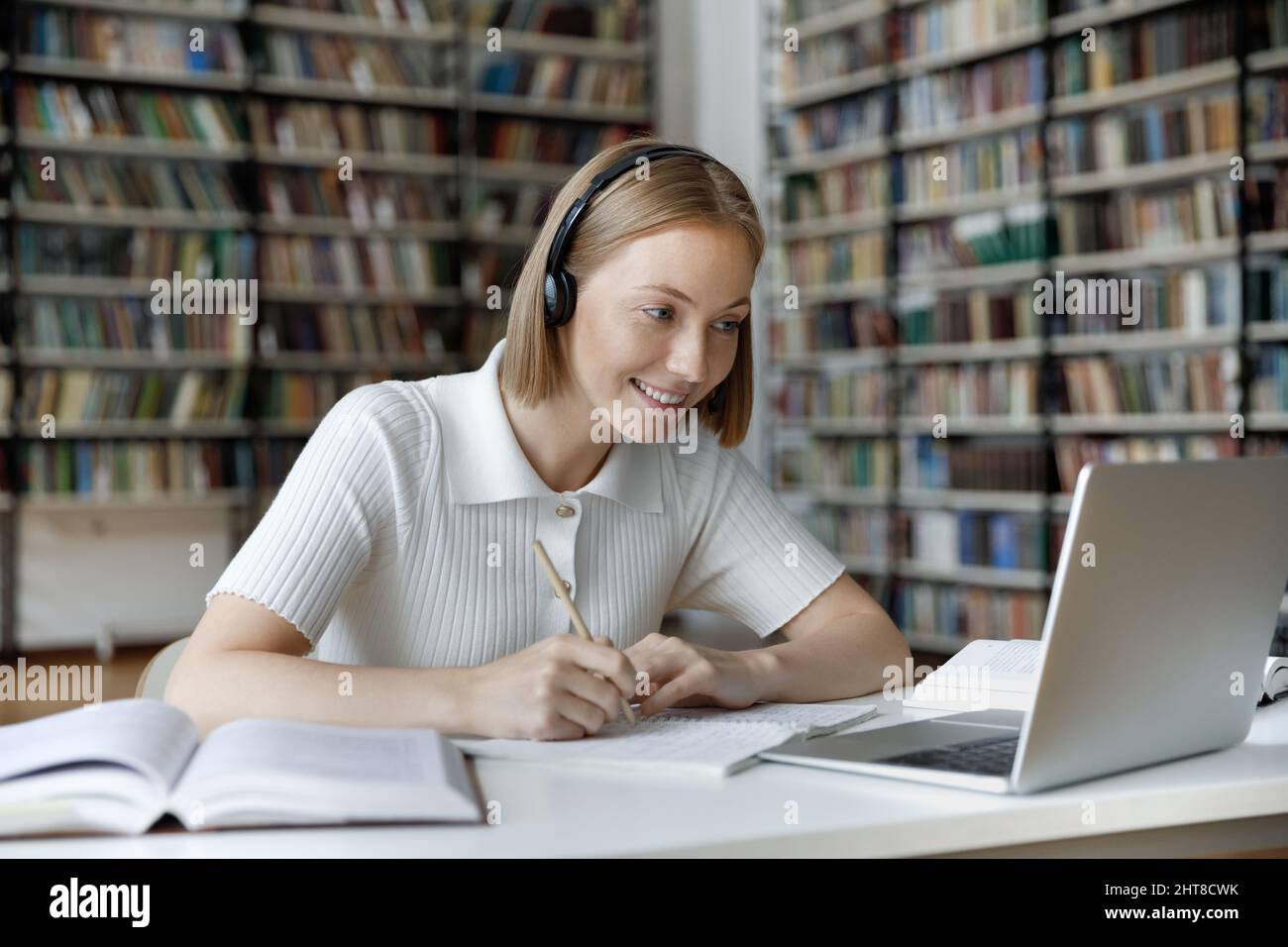 Happy young beautiful female student watching educational lecture. Stock Photo