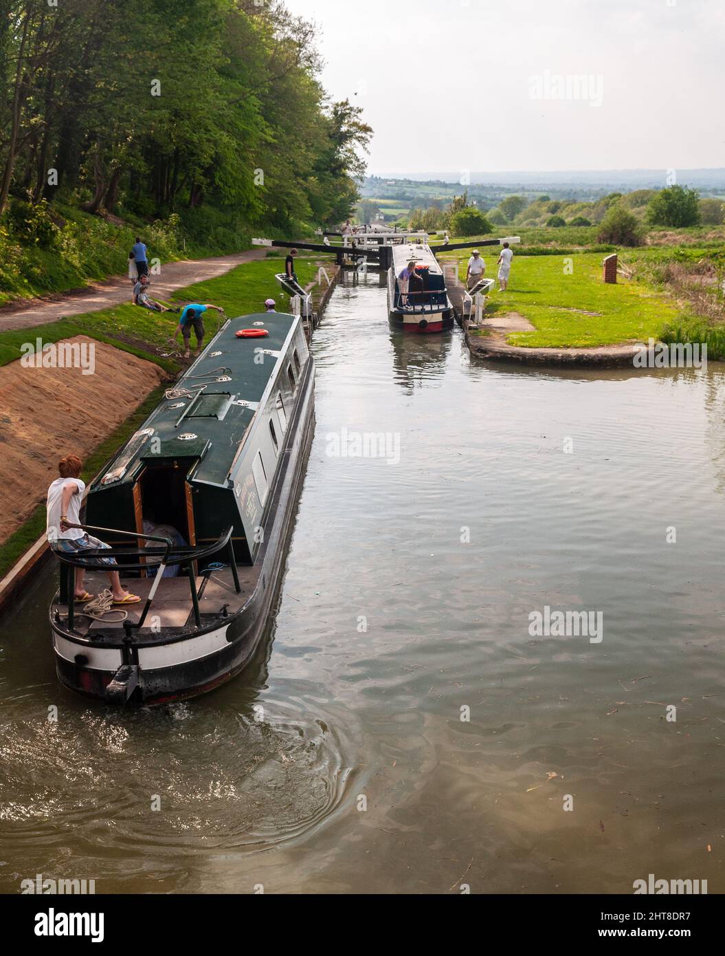 Narrowboaters descend the Caen Hill Locks on the Kennet and Avon Canal at Devizes in Wiltshire. Stock Photo
