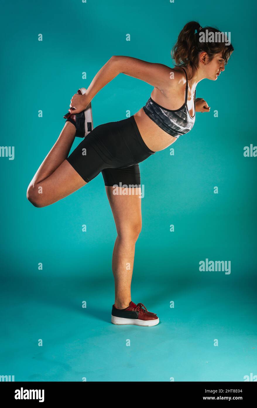 Side view of young athletic woman in sportswear exercising Stock Photo ...
