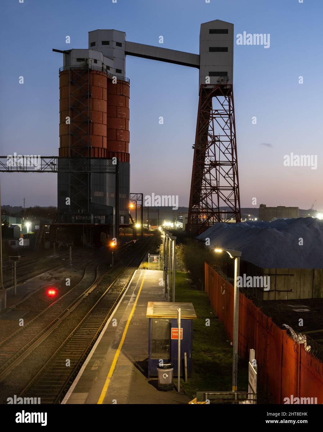 A conveyor elevator and silos for loading coal trains stands over railway tracks at St Andrew's Road station in Avonmouth, Bristol. Stock Photo