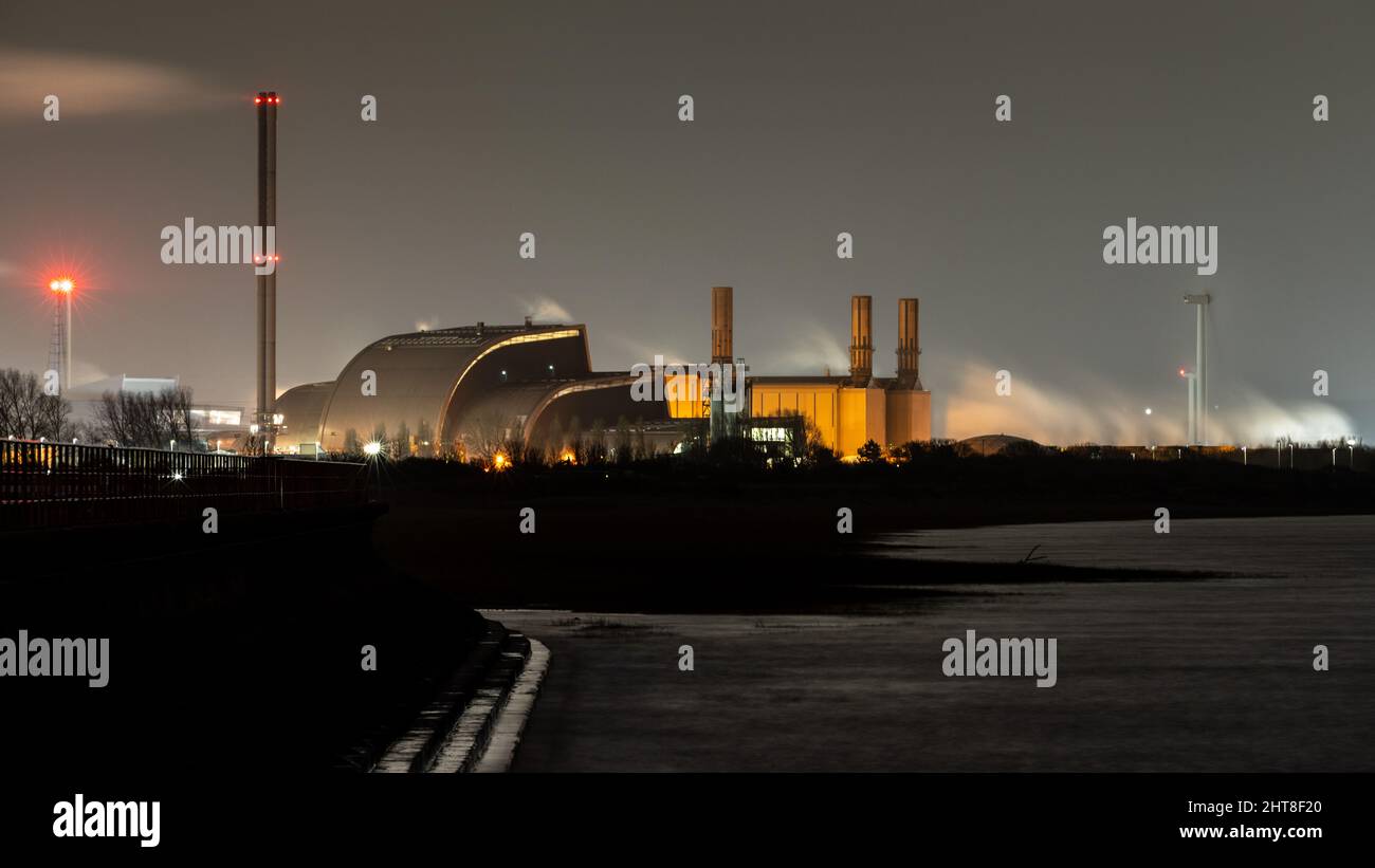 Steam rises from Severnside Energy Recovery Centre and Seabank Power Station at night in the industrial Avonmouth area of Bristol. Stock Photo