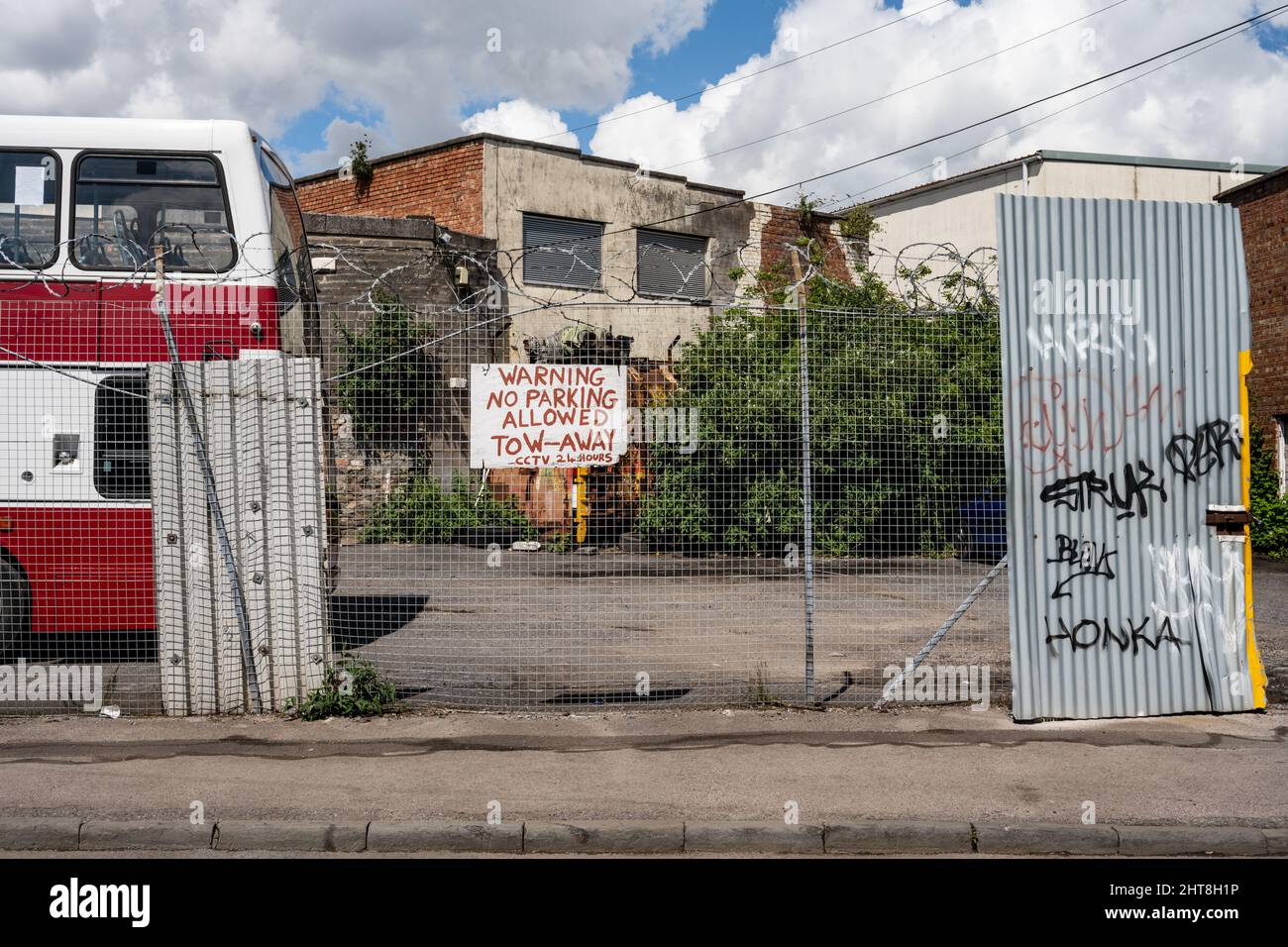 An old double-decker bus is parked beside light industrial workshops on Gas Lane, an inner city regeneration area scheduled for urban renewal in Brist Stock Photo