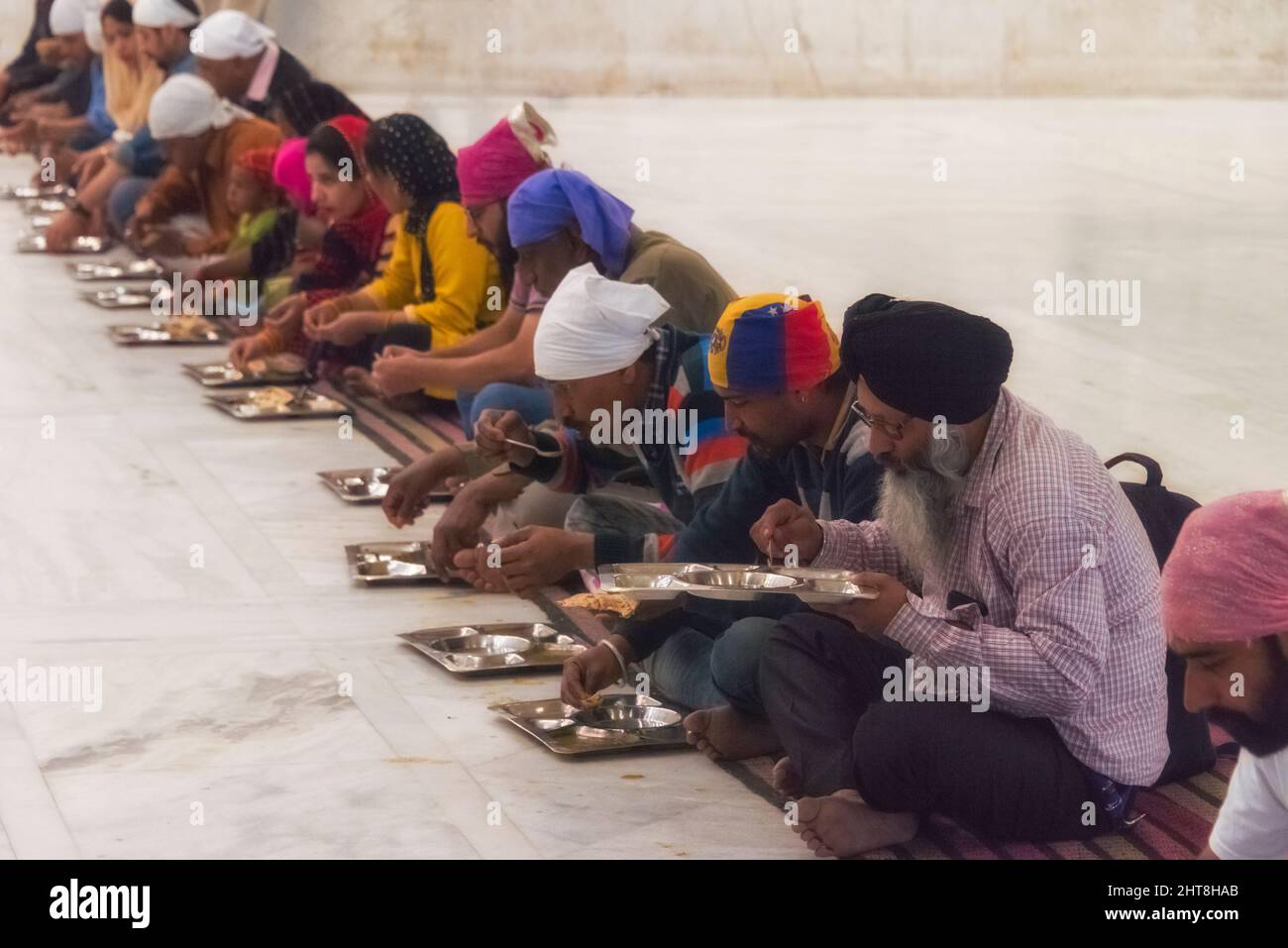 Pilgrims eating inside Gurudwara Bangla Sahib, Sikh house of worship, New Delhi, India (Gurudwara Bangla Sahib, the largest Sikh temple in Delhi, serv Stock Photo