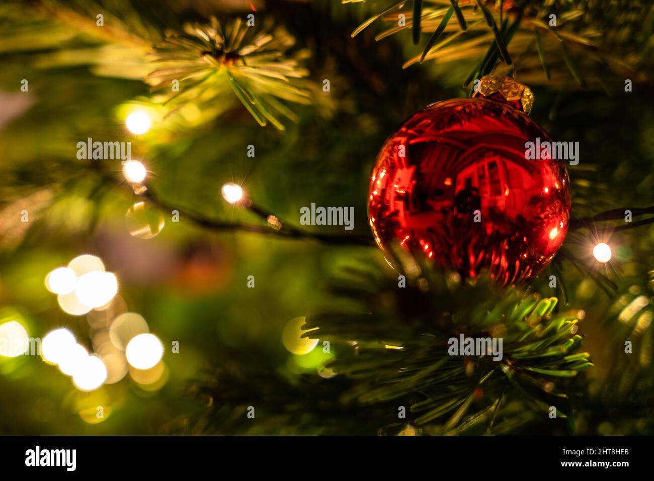 Red ball hanging on a branch of a decorated Christmas tree Stock Photo ...