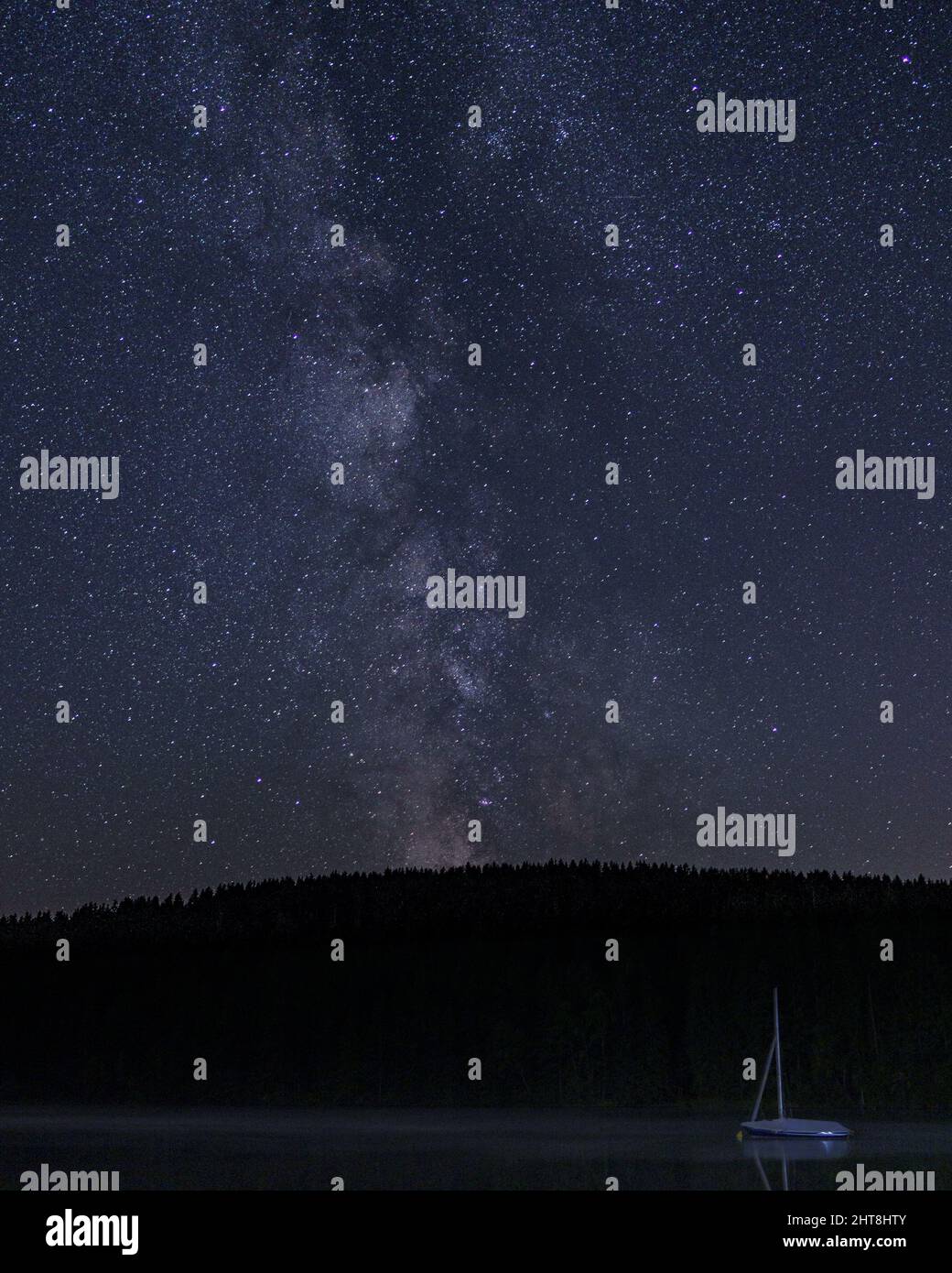 Vertical shot of the beautiful Milky Way in the night sky full of stars ...