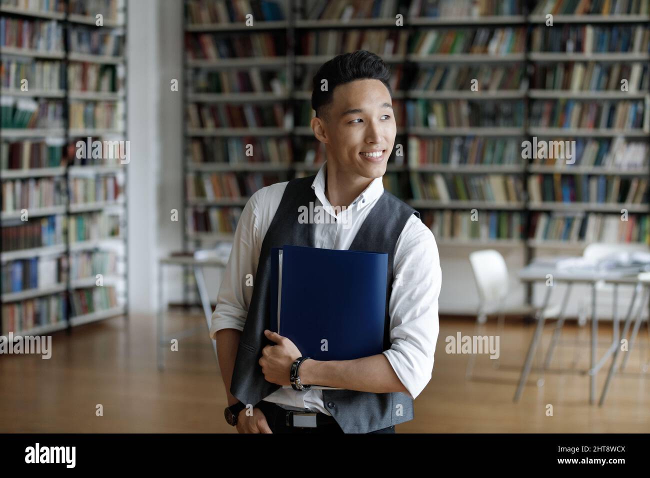 Thoughtful young handsome Asian student looking in distance. Stock Photo