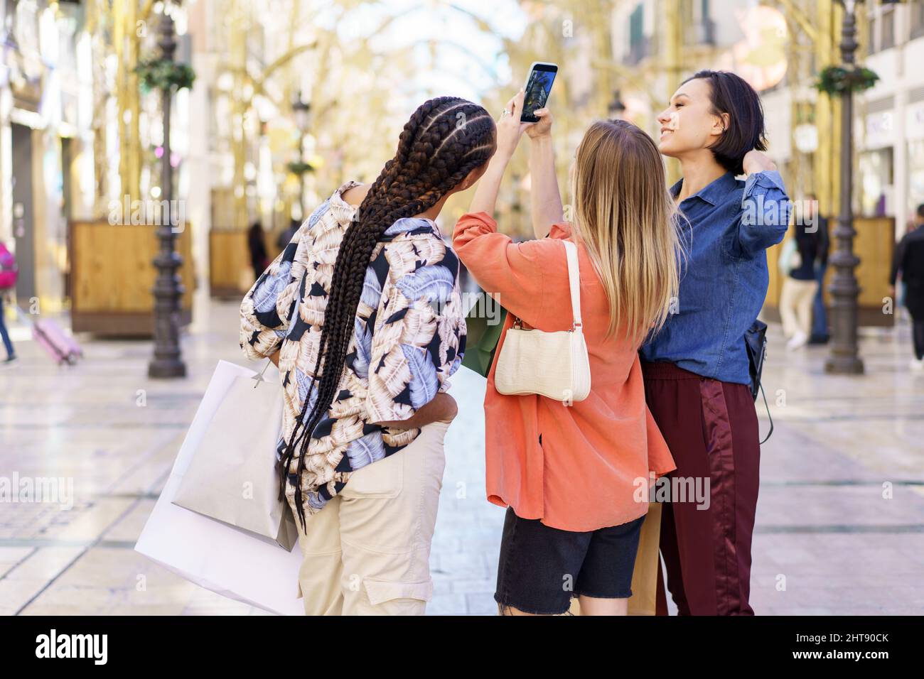 Stylish diverse women standing on street and taking photo Stock Photo