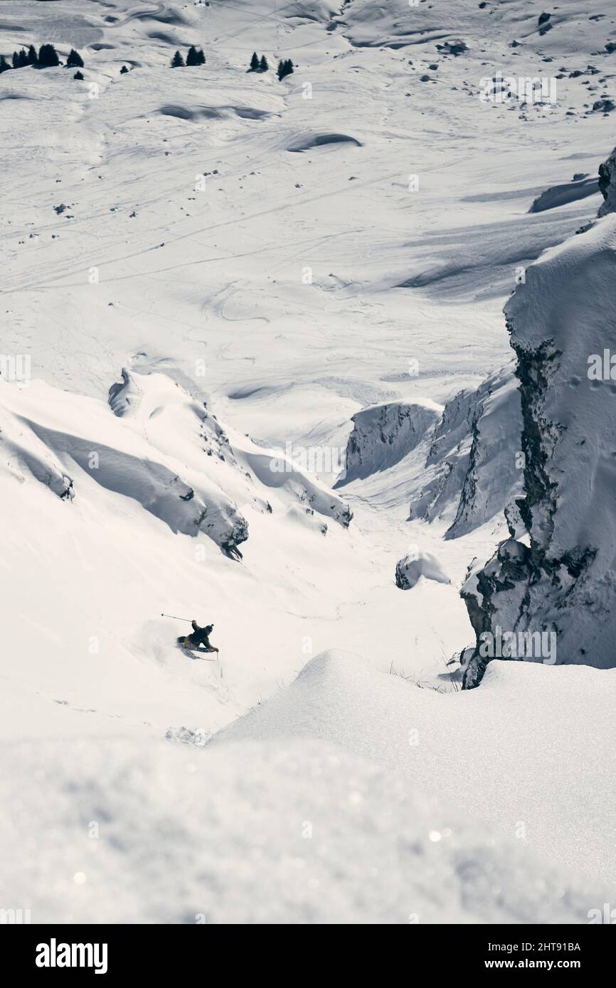 The skier slips covered with snow on a high mountain descending road