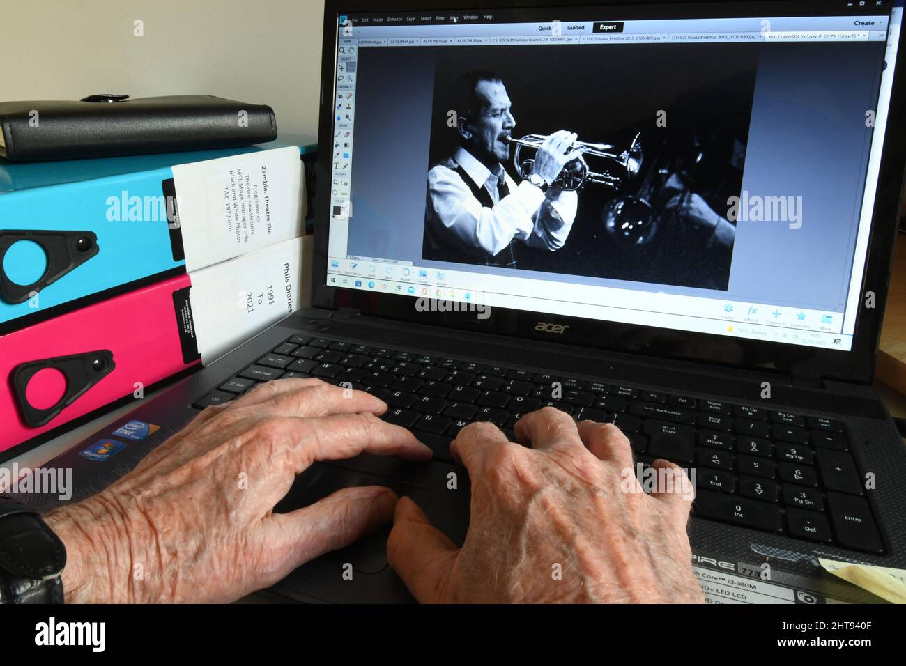 Old Hands at a computer keyboard finding pictures to trigger pleasant memories as one gets older. Music performances bring many happy memories such as Stock Photo