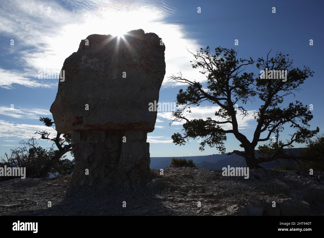 Morning sun rises behind a hoodoo at Shoshone Point on top of the South Rim of the Grand Canyon. Shoshone Point is named after the Shoshone tribe, a N Stock Photo