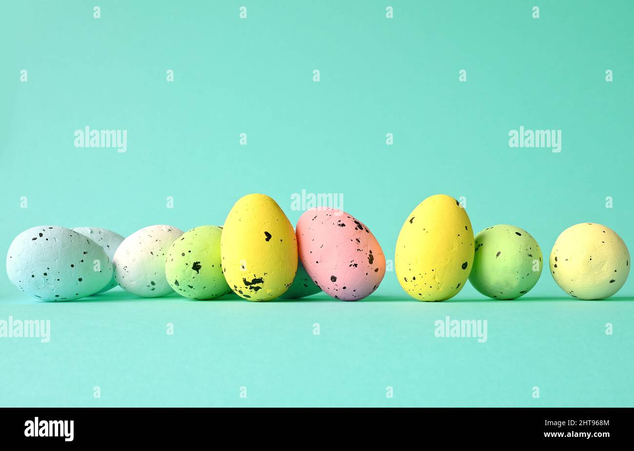 Row of painted colored easter eggs on blue background. Happy Easter background. Stock Photo