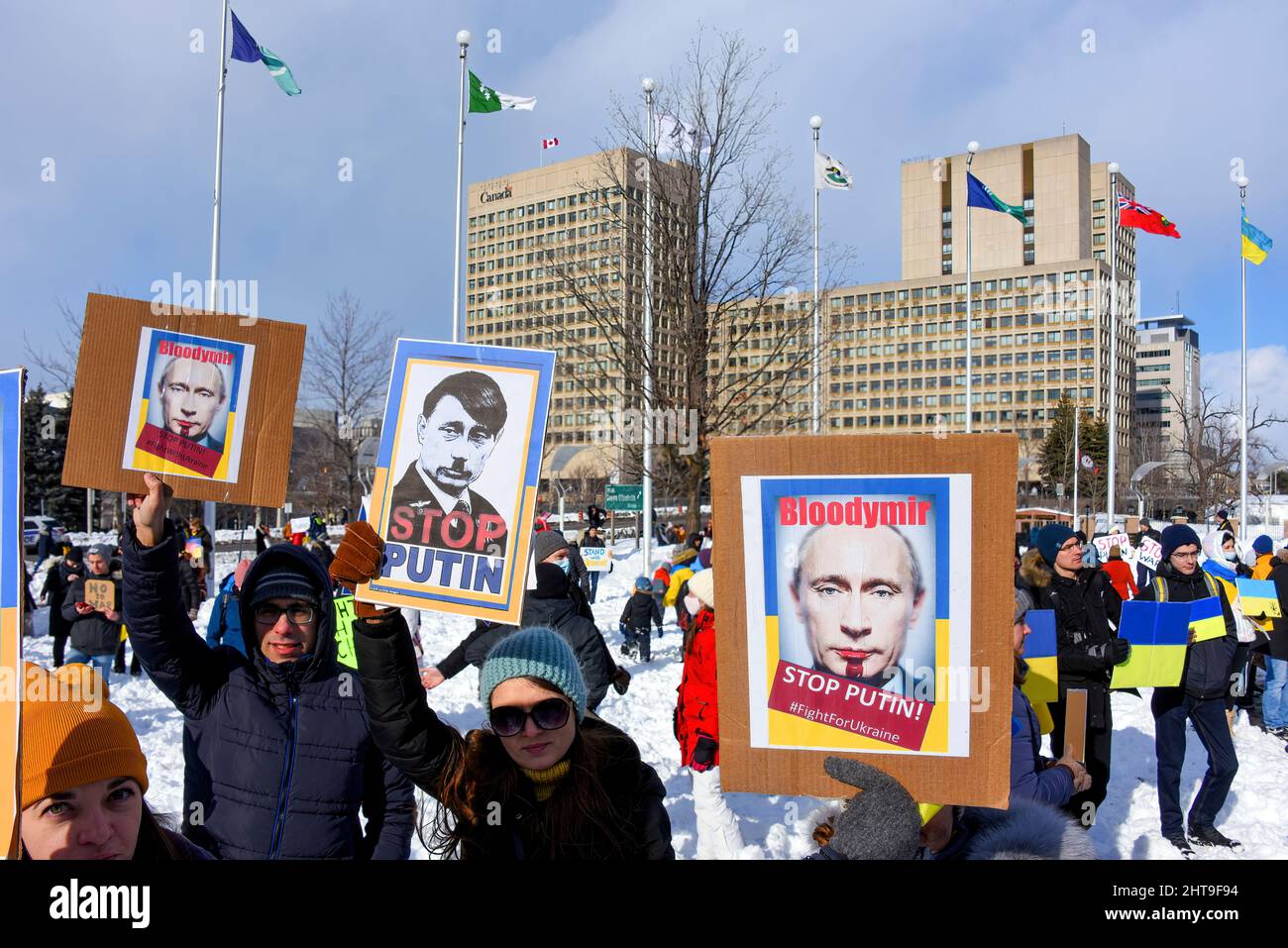 Ottawa, Canada - February 27, 2022: People hold anti-Putin signs at the Ottawa Stands With Ukraine Rally and March to protest the Russian invasion of Ukraine. It started at the Russian Embassy and ended up at Ottawa City Hall. Canada has the world's third-largest Ukrainian population behind Ukraine itself and Russia. Stock Photo