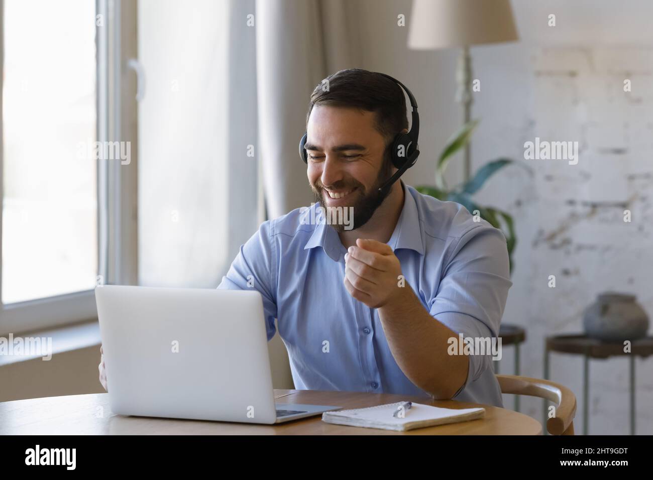 Man wear headset using laptop working from home Stock Photo
