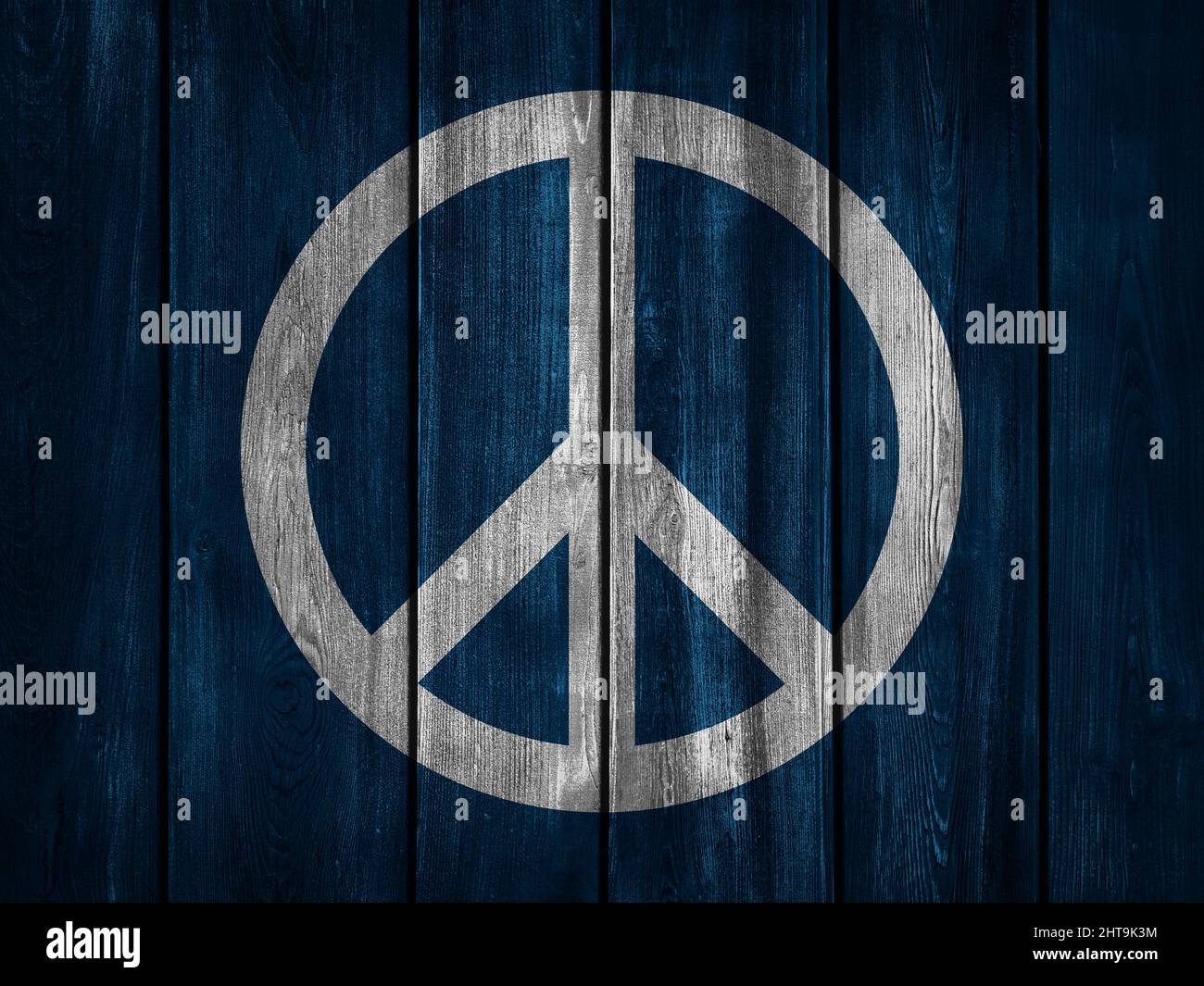 Peace background. White symbol of peace on dark blue wooden background. Stock Photo