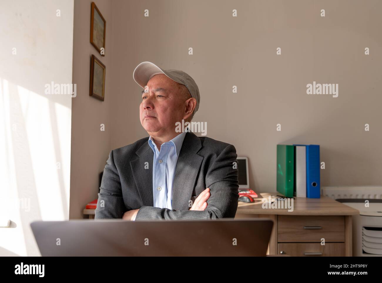 A business man in his office with crossed arms and a proud expression. Stock Photo