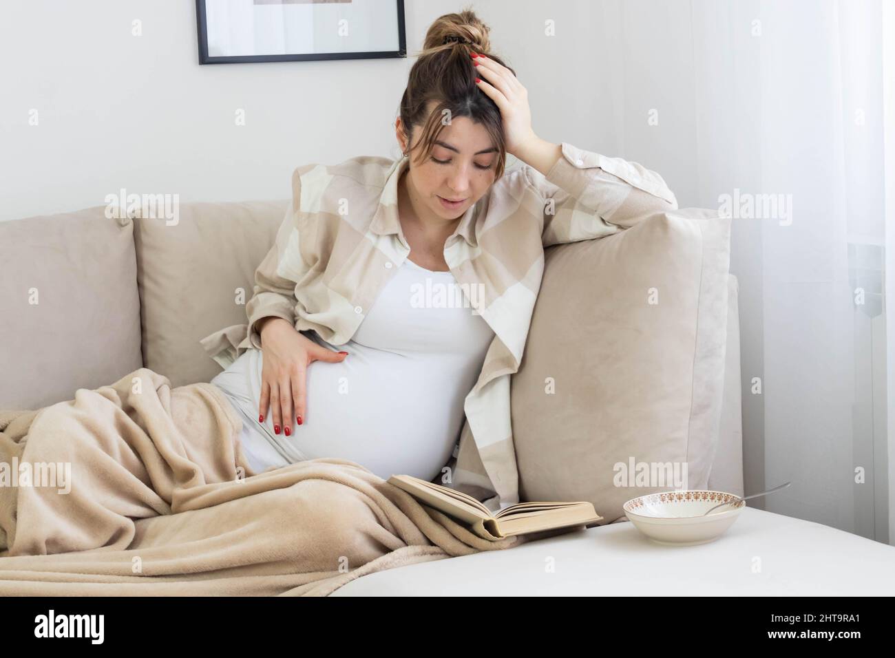 A Caucasian pregnant woman from Bosnia and Herzegovina reading a book Stock Photo