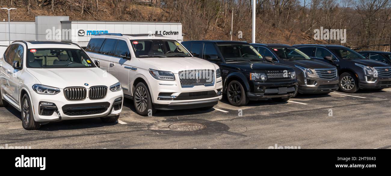 Different luxury vehicles lined up for sale on a car dealership lot in