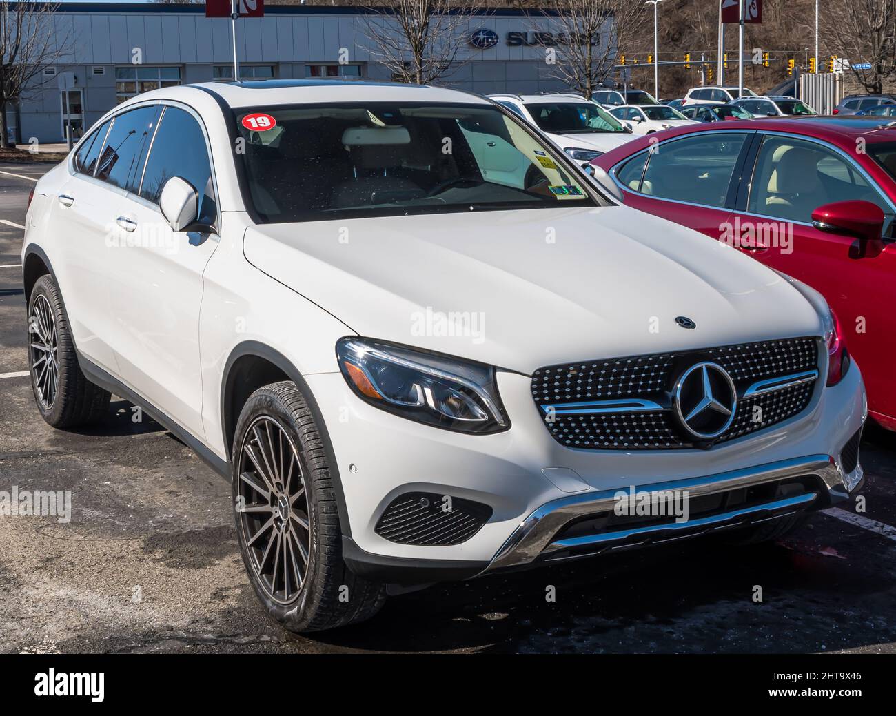 A used white Mercedes Benz SUV for sale on a used car dealership lot in