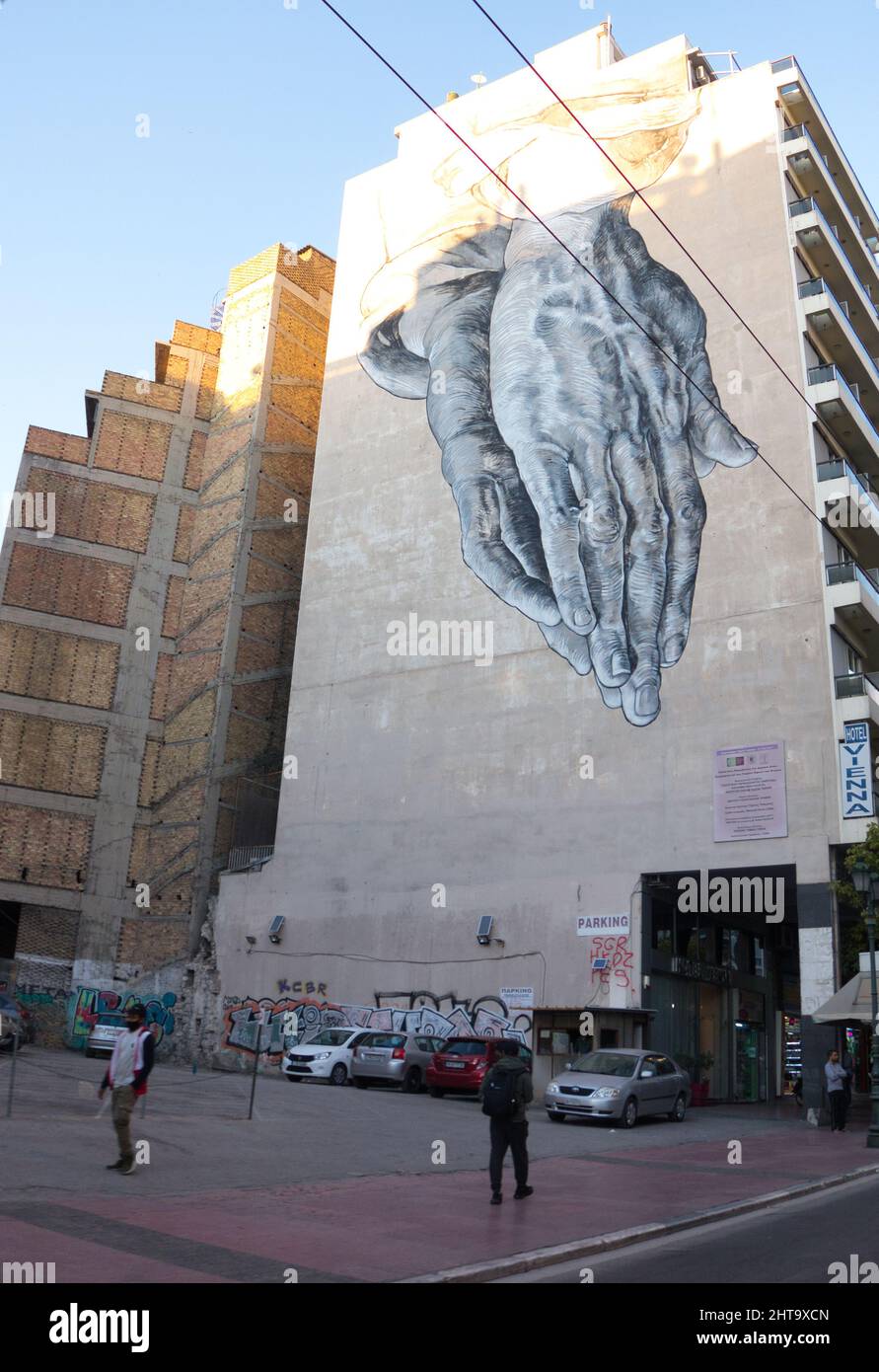 Vertical shot of praying hands graffiti on a building in Athens, Greece ...