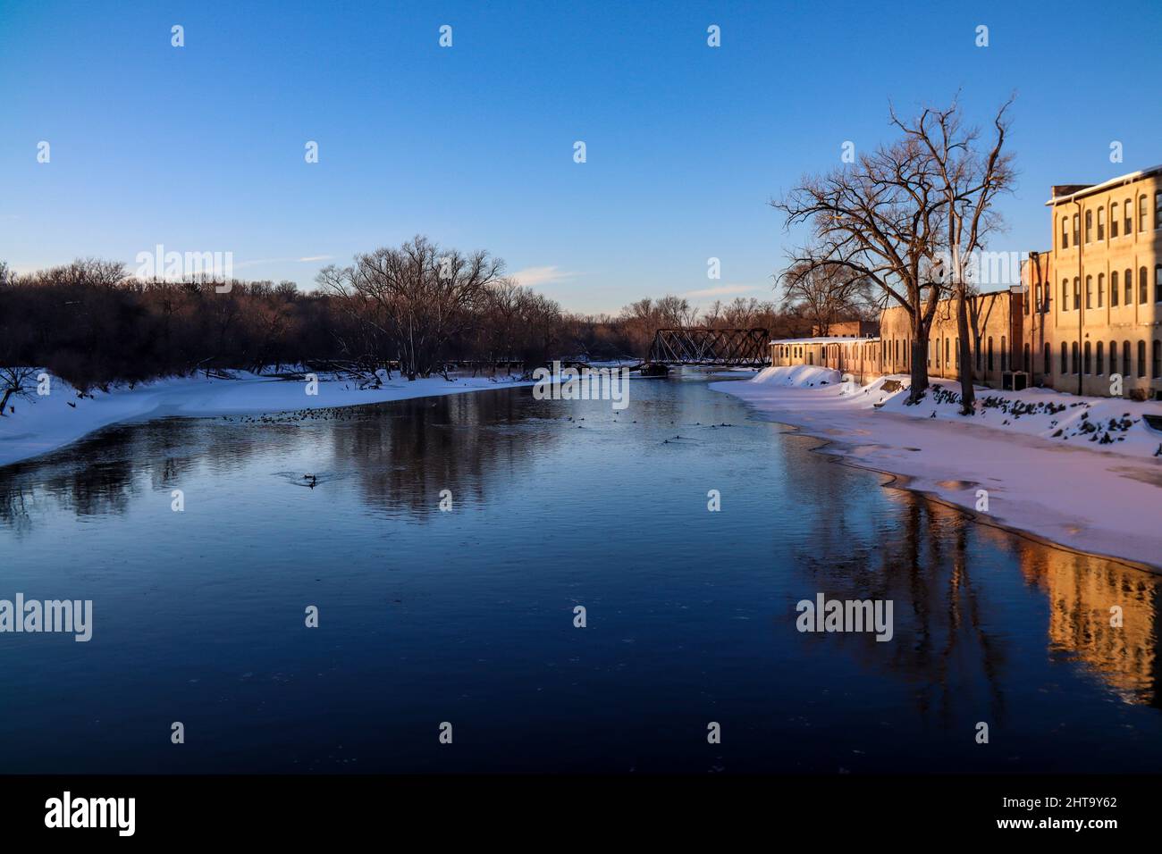 Panoramic view of a river flowing through an urban area on a sunny winter day Stock Photo