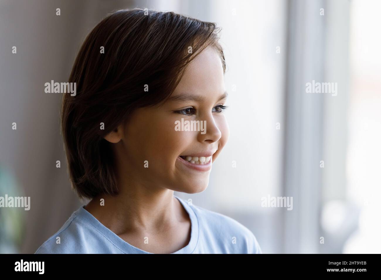 Closeup portrait cute little boy smiling looking into distance Stock Photo