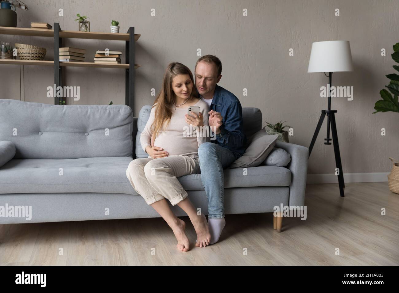 Happy young couple using virtual mobile service, online app Stock Photo