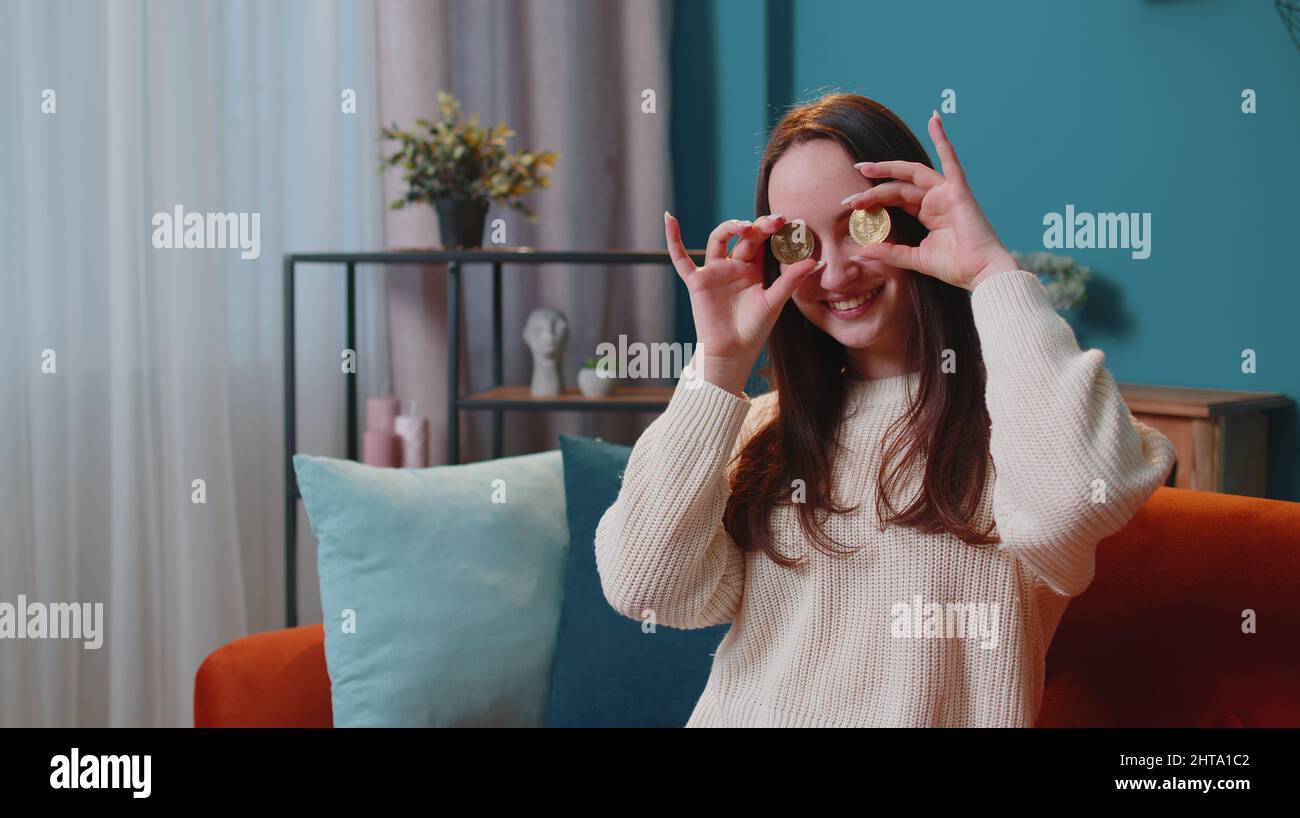 Woman freelancer holding two gold coins at home, successful developer  programmer, earning bitcoins Stock Photo - Alamy