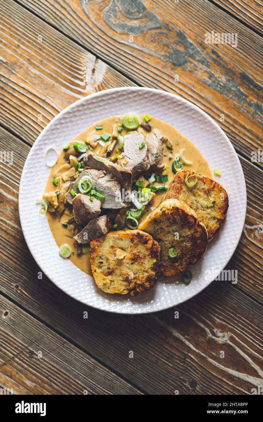 Top view of a pork tenderloin with homemade dumplings and spring onion